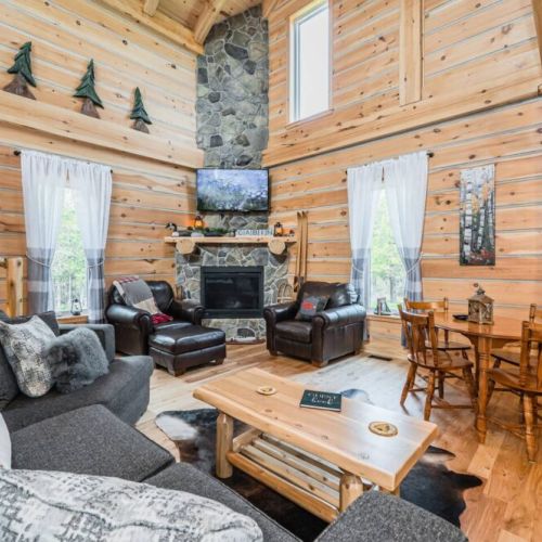 Welcome to the spacious great room of Saw N' LogzzZ, where 25' ceilings and a towering stone fireplace evoke the splendor of a bygone era lodge. Enjoy the southern exposure's splendid afternoon light.