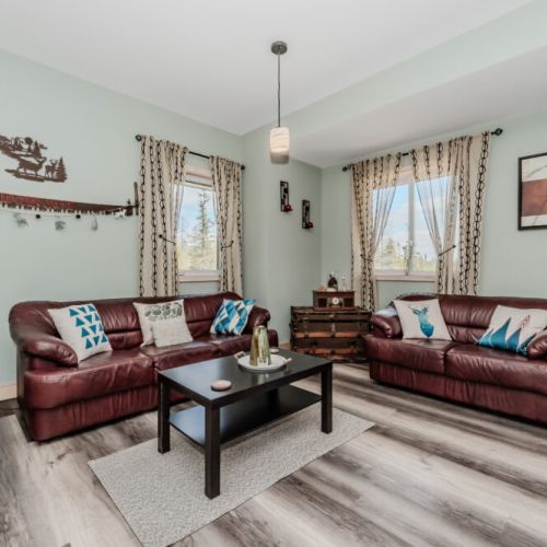 Kick back in this inviting lounge with forest views, warm wood accents, and plush leather seating—your retreat after a day exploring Bruce Peninsula.