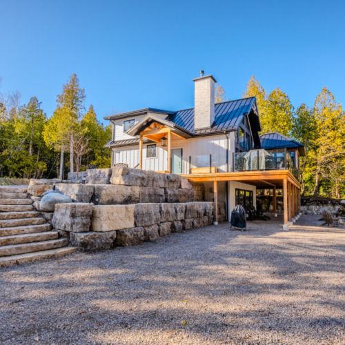 Wake up in paradise at this stunning vacation rental featuring modern architecture, a spacious deck, and natural stone stairs—perfect for outdoor adventures and serene retreats near the lake.
