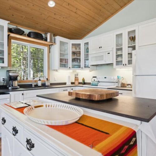 The fully equipped kitchen has everything you need to prepare meals, with plenty of counter space and beautiful forest views from the sink.
