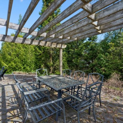 Covered pergola dining area perfect for outdoor meals and relaxing summer evenings.