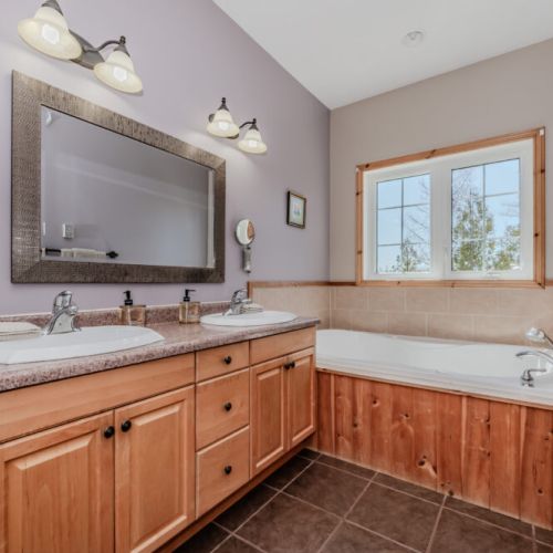 Spacious ensuite bath with dual vanities and a deep soaker tub – ideal for unwinding after beach or hiking adventures.