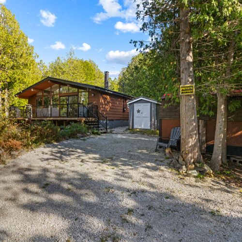 A spacious driveway provides plenty of parking, with the cottage tucked privately among the trees.