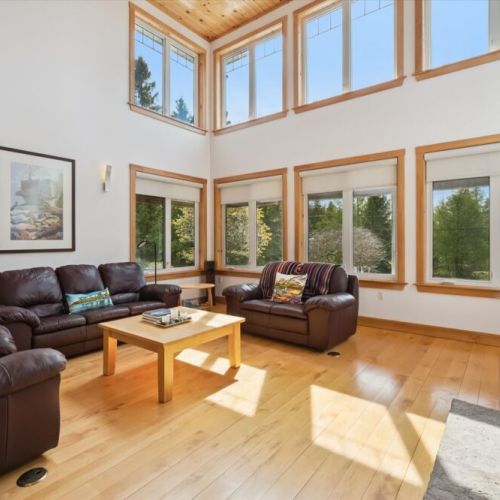 Sun-filled great room with towering windows and relaxing seating area.