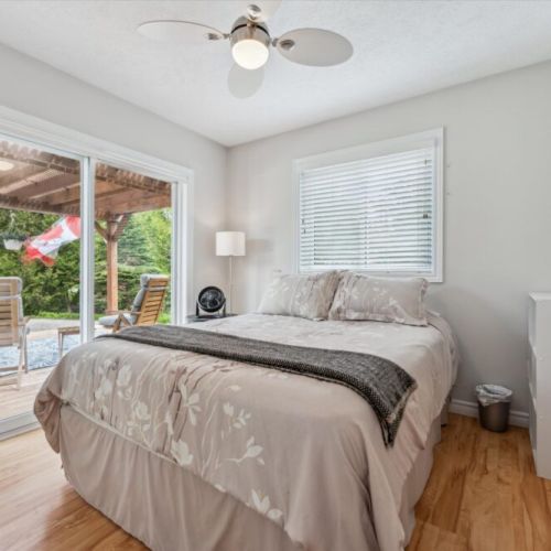 Main floor bedroom with patio walk-out – Wake up to forest views and step out to the patio for your morning coffee.
