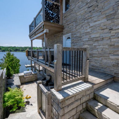 Multi-level outdoor space with stairs leading down to the waterfront and dock.