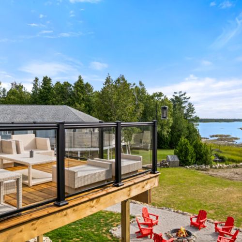 Enjoy peaceful waterfront views from the deck while gathering around the outdoor seating area.