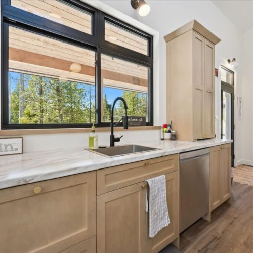Bright kitchen with beautiful forest views and easy outdoor access.