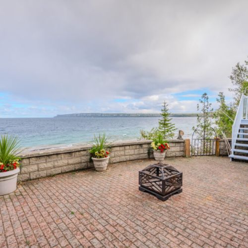 Take in panoramic views of Isthmus Bay from the waterfront patio, surrounded by lush greenery and vibrant flowers. A serene escape after kayaking, hiking, or discovering local treasures like Flowerpot Island.