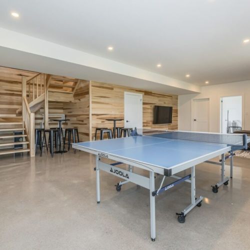Professional table tennis table in the spacious games space, with couches in the corner lounge perfect for relaxing conversation or waiting for the next game.