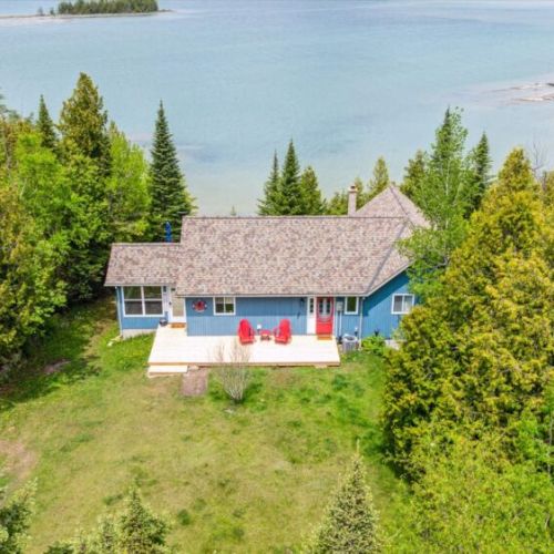 The red Muskoka chairs on the spacious deck welcome you to relax, unwind, and take in unbeatable lakefront sunsets.