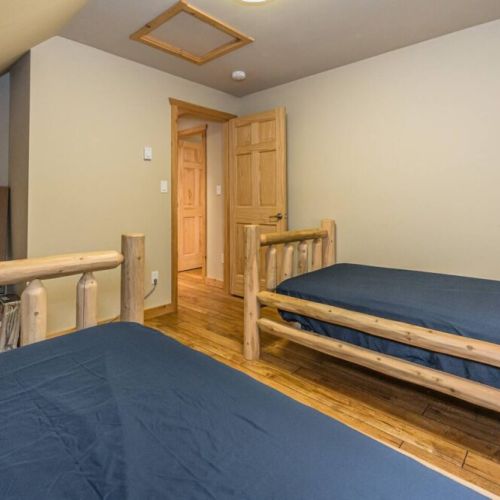 Comfortable twin beds in a room that blends seamlessly with the cabin's rustic aesthetic, providing a peaceful setting for dreaming away.