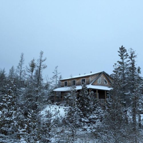 Tucked in a winter wonderland—Sunny Meadow Place looks magical dusted in fresh snow, surrounded by silent forest.