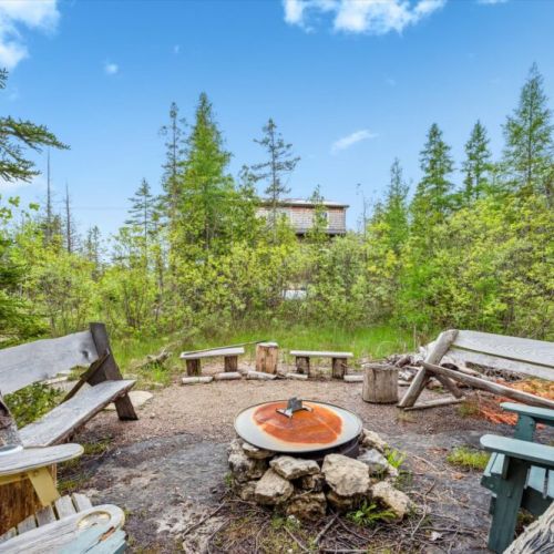 Look back toward the cottage from the fire pit, which offers a perfectly framed retreat among the trees—just a short stone path away from the warmth and laughter of the fire.