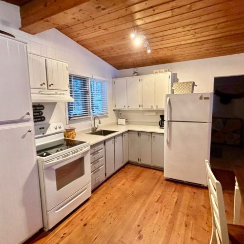 Cozy Dining & Cooking Space – This open kitchen and dining area blends rustic charm with modern convenience. The wood ceilings and white cabinetry create a warm, inviting atmosphere for family meals or morning coffee.