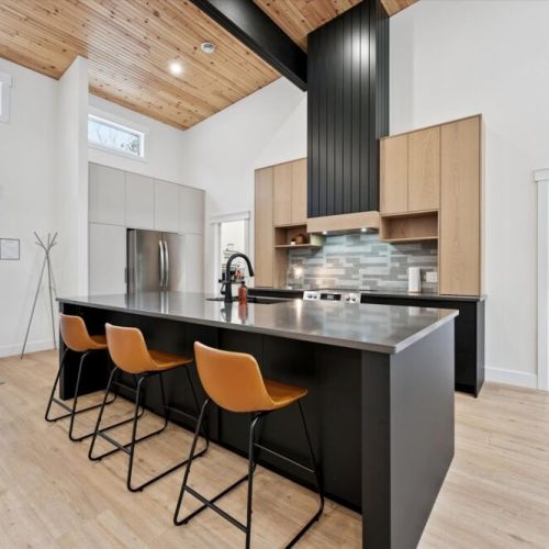 Chef’s kitchen with island seating offering modern appliances, generous prep space, and seating for casual meals.