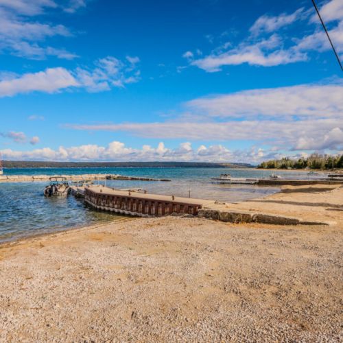 A scenic view of the lake with a breakwater, offering both stunning vistas and protection from waves for a tranquil swimming experience.