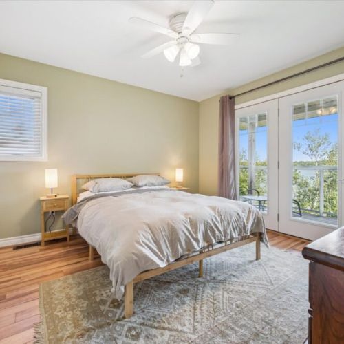 Bright and airy bedroom with direct access to a private balcony and stunning lake views.