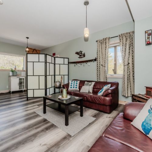 Spacious open-concept living area with leather sofas, stylish decor, and lots of natural light—ideal for family gatherings or group getaways.