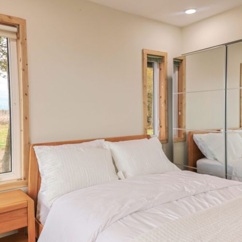 Tranquil Retreat: Escape to tranquility in this serene bedroom. The queen-size bed, dressed in hotel-like linens, and breathtaking lake views create the perfect setting for a peaceful and restful night's sleep.