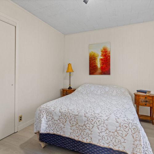 A comfortable main-floor bedroom with a cozy bed, bedside lighting and plenty of space to settle in.