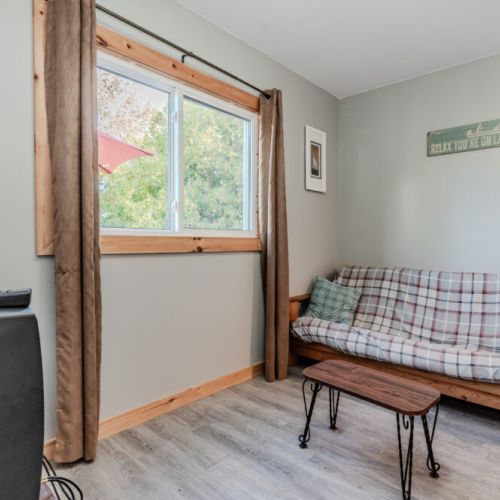 The living area offers comfortable seating with plenty of natural light, creating a warm and inviting ambiance.