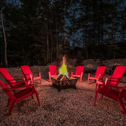 Gather around the fire pit for a memorable night under the stars. Red Adirondack chairs encircle the glowing fire, offering a warm and inviting spot for storytelling and toasting marshmallows.