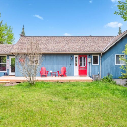 Welcoming and full of charm, the bright red door and patio seating offer a warm first impression of Myles Bay Retreat.