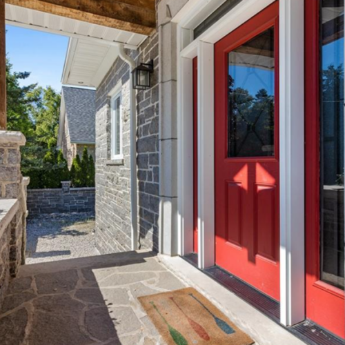 A warm welcome awaits you at the entrance of the Lion's Den, featuring a vibrant red door that adds a touch of charm and character.