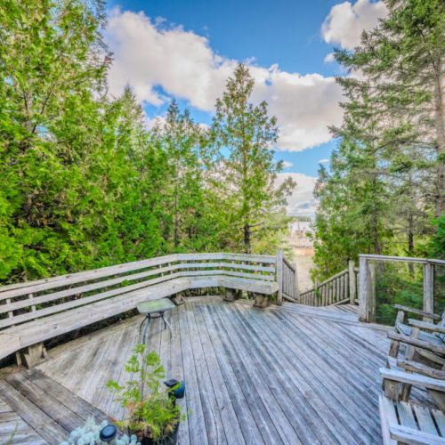 Multiple seating options on this spacious deck create the ideal space for gatherings or quiet moments, all while being immersed in the tranquility of the surrounding forest.