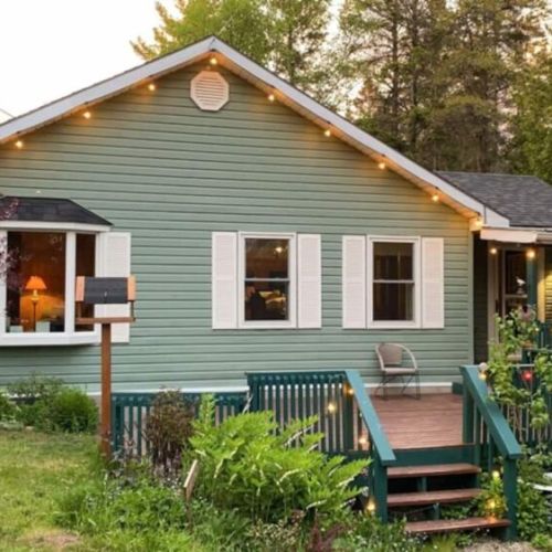 Storybook charm meets cozy comforts in this lit-up cottage exterior. A welcoming home base for magical nights and nature-filled days.