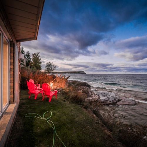 Outdoor fire pit with seating by the water’s edge, perfect for evening bonfires under the stars.
