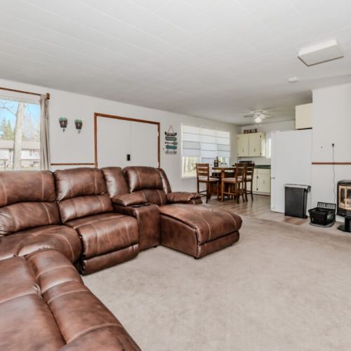 Warm up by the classic wood-burning stove in this bright and open lounge area—ideal for cozy cottage evenings after outdoor adventures.