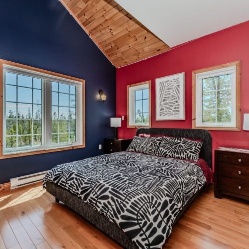 Bold and colourful bedroom with forest views—perfect for a stylish and peaceful vacation stay.