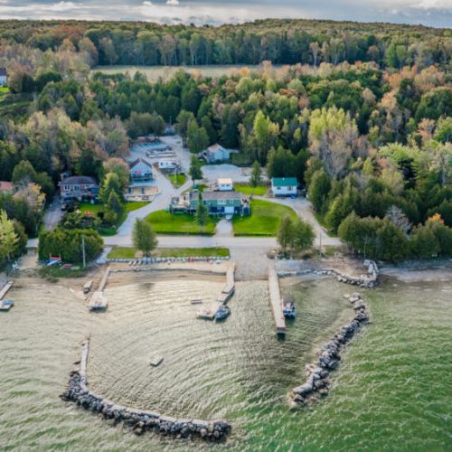 An aerial shot showing the cabins nestled in a lush, wooded area, with easy access to the waterfront and amenities.