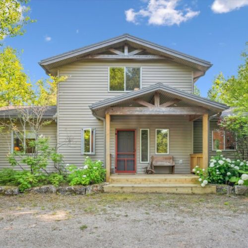 Welcoming exterior with charming covered porch and rustic seating — a warm first impression as you arrive at your secluded retreat.
