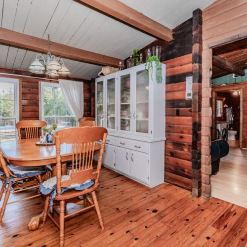 Unwind at this charming log cabin vacation rental featuring a bright dining area with forest views, rustic wood interiors, and modern comforts—ideal for family vacations, romantic retreats, or cozy nature escapes year-round.