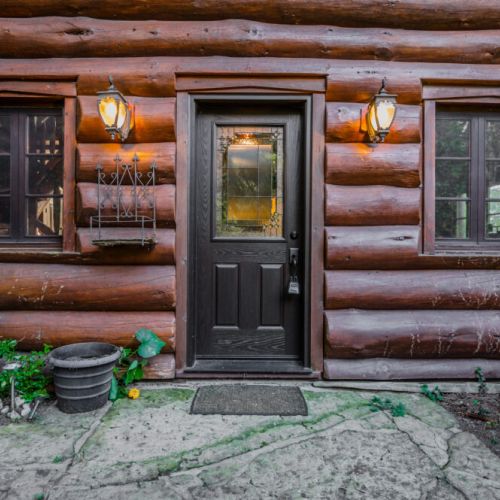 Step through this charming log-cabin entryway into a world of rustic elegance. Warm wood tones and thoughtful craftsmanship set the tone for a luxurious and inviting interior experience.