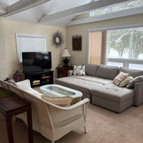 Cozy lounge area with a sectional and large windows that bring in lots of natural light.
