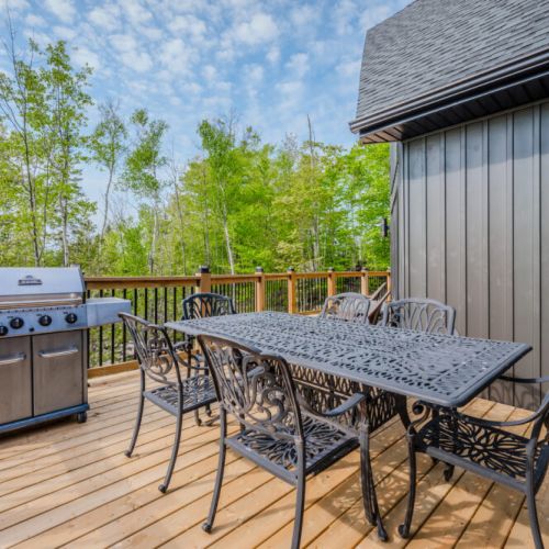 The spacious deck features a BBQ grill and an outdoor dining table, making it ideal for al fresco dining and enjoying the fresh air.