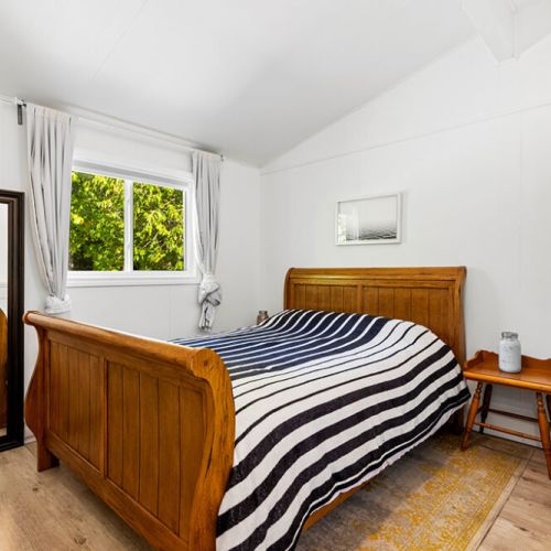 The second bedroom is bright, comfortable, and surrounded by peaceful forest views.