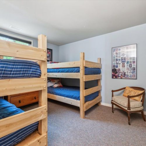 Cozy and fun, this room features two sets of solid wood bunk beds with nautical bedding, perfect for kids or extra guests.