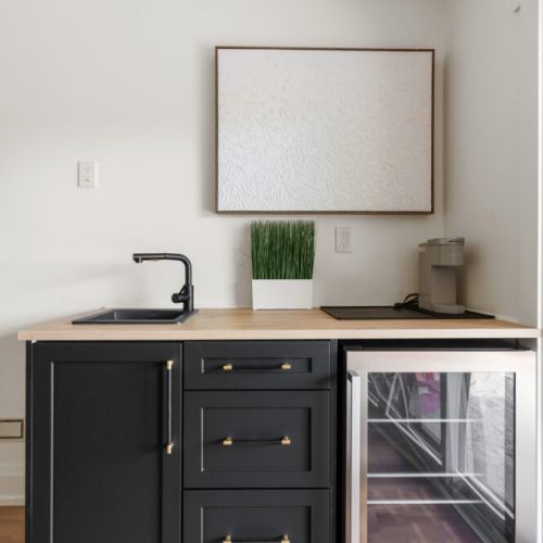 A convenient beverage station includes a mini fridge, sink, and coffee maker.