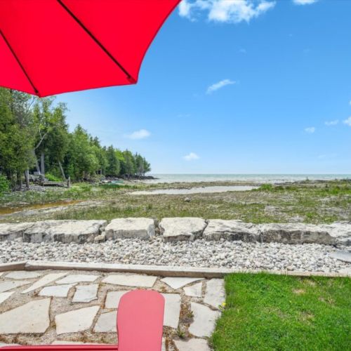 Unwind under the umbrella with front-row views of Lake Huron — the perfect setting for coffee, cocktails, or quiet reflection.