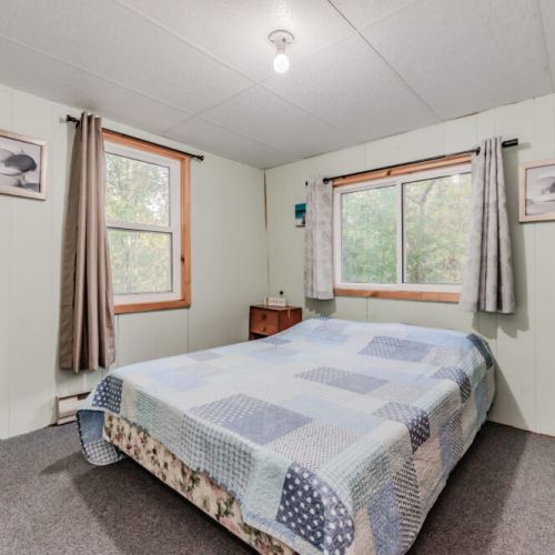 A comfortable bedroom with a large bed, wardrobe, and bedside table, offering a peaceful retreat after a day of adventure.