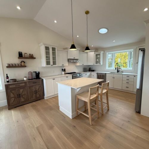 Entertain in a bright, fully stocked kitchen with high ceilings, modern fixtures, and large island seating—perfect for group meals.