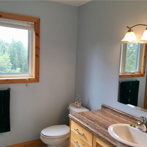 The clean and bright bathroom includes modern fixtures and cottage comforts for your stay.