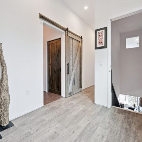 A modern entryway with sliding barn doors and clean lines that sets the tone for the home’s thoughtful, design-forward style.