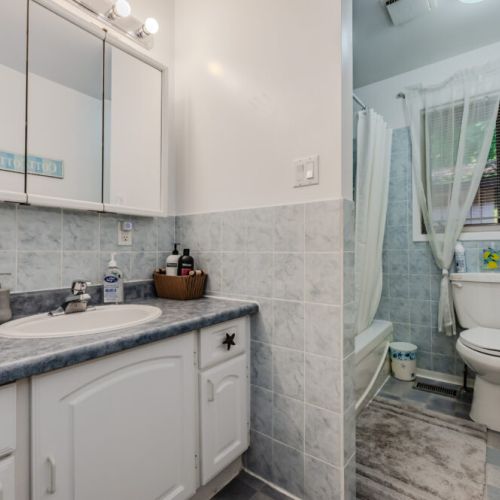The clean, well-maintained bathroom features all the essentials for a comfortable stay, including a shower and ample counter space.