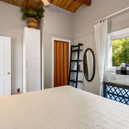 The spacious primary bedroom features vaulted wood ceilings and calming natural light.